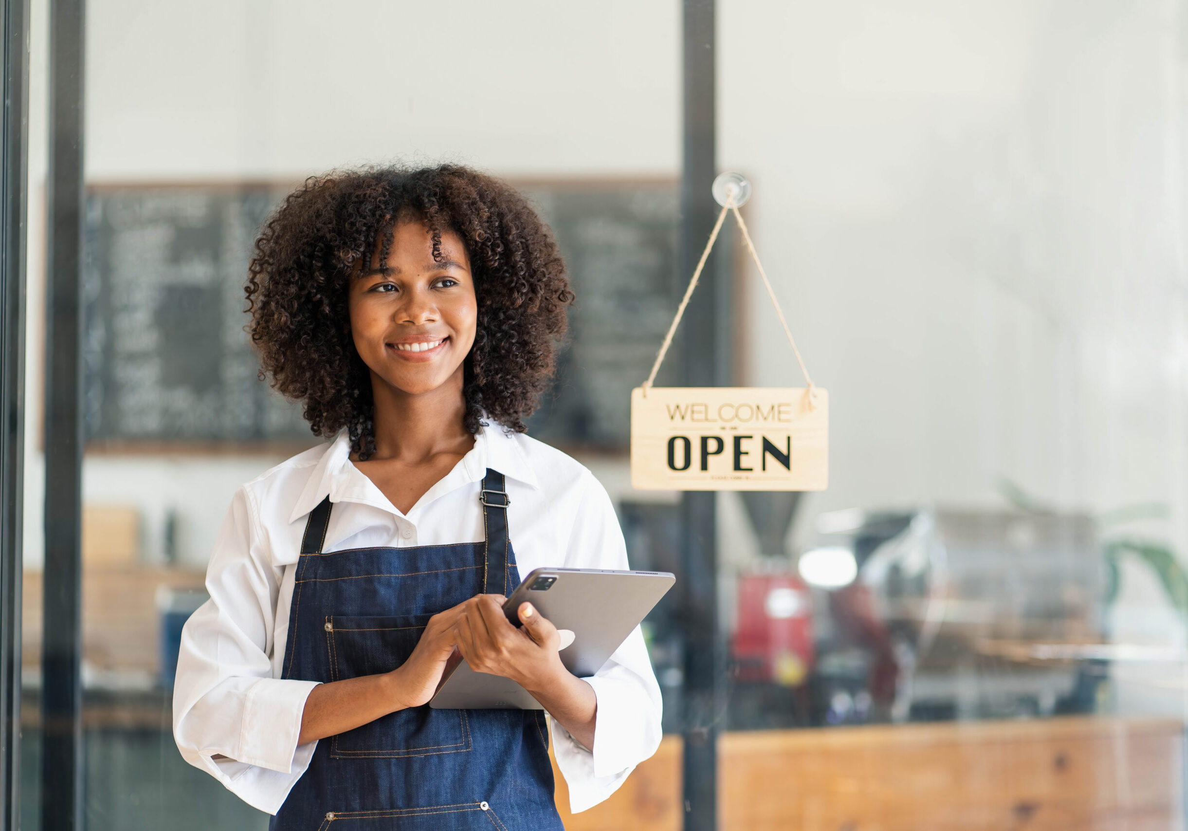 Startup successful small business owner sme beauty girl stand with tablet smartphone in coffee shop restaurant. Portrait of asian tan woman barista cafe owner SME entrepreneur seller business concept..